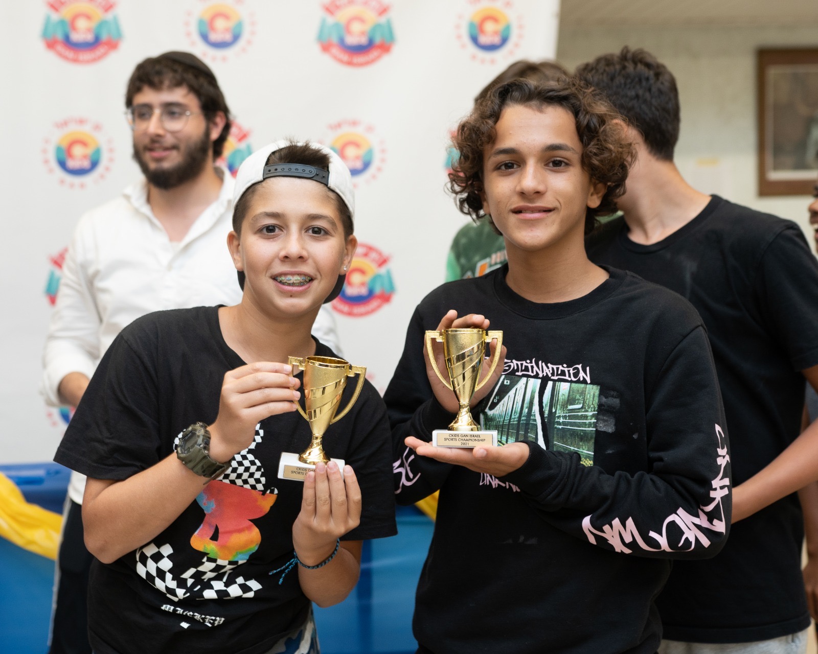 Campers holding sports championship trophies